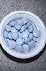 Oxycodone 30 mg IR blue tablet with 'K 9' imprint displayed on a white plate.