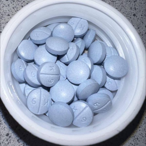 Oxycodone 30 mg IR blue tablet with 'K 9' imprint displayed on a white plate.