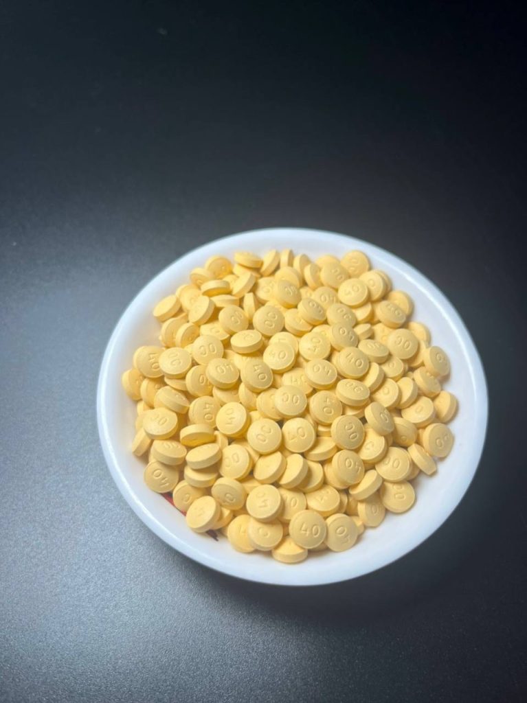 Multiple OxyContin 40mg yellow tablets in a transparent jar – real prescription painkillers comes in blister.